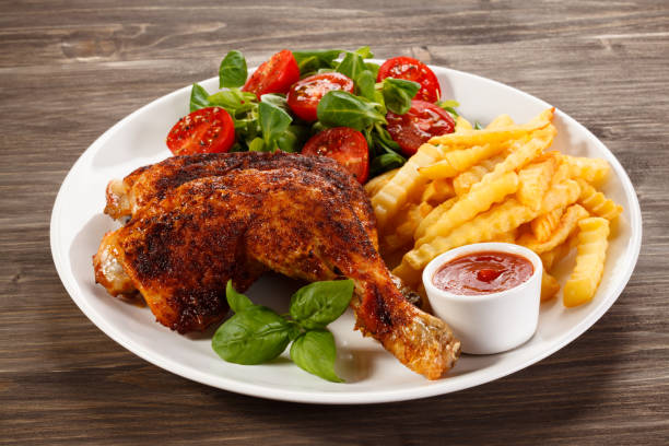 Grilled chicken legs with chips and vegetables